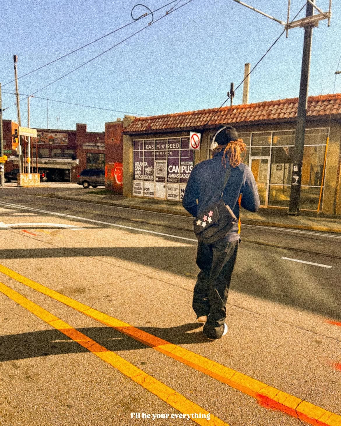 Yari crossing a city street in warm afternoon light