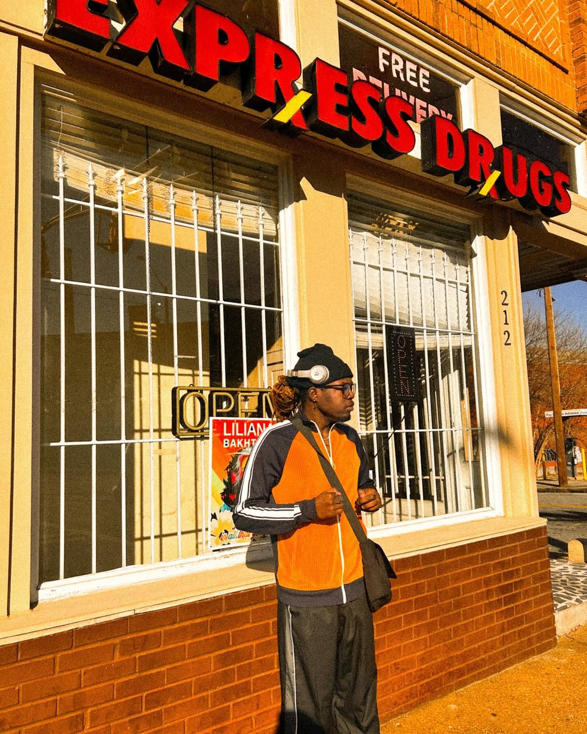 Yari in orange and navy standing outside a neighborhood storefront